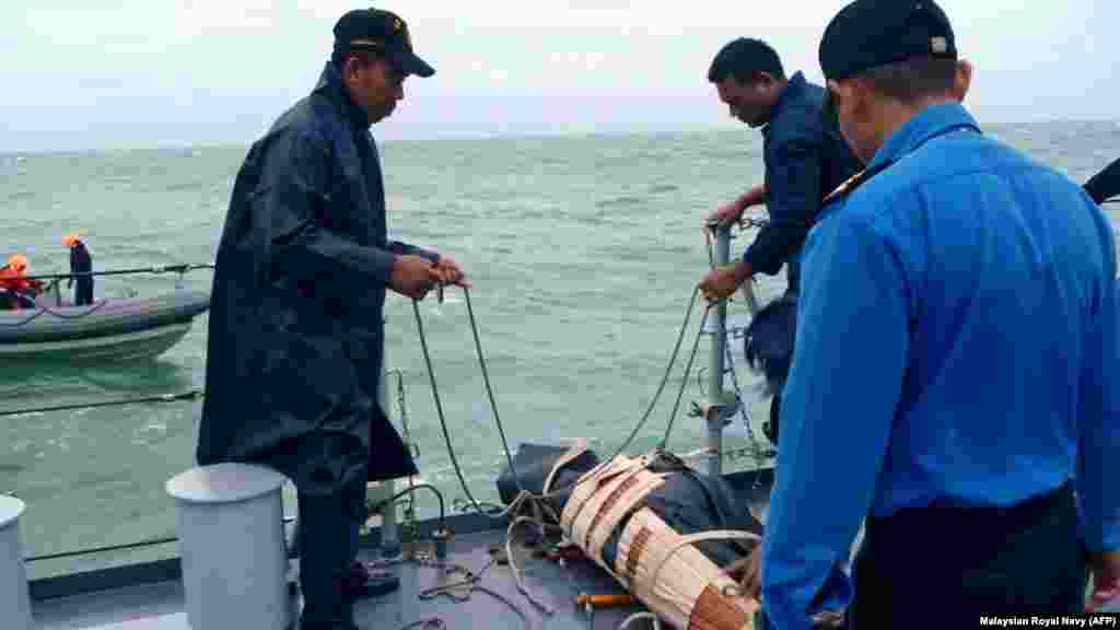 Royal Malaysian Navy crews retrieve a victim from AirAsia Flight 8501 during their search-and-rescue operations in Indonesia's Java Sea, Dec. 31, 2014.