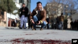 Seorang jurnalis Afghanistan merekam suasana di sekitar lokasi penembakan di Kabul, Afghanistan, 17 Januari 2021. (AP Photo/Rahmat Gul)