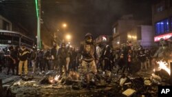 Demonstran berhadapan dengan polisi dalam aksi protes yang dipicu oleh kematian seorang pria dalam tahanan polisi, di Villa Luz, Bogota, Kolombia, 9 September 2020.