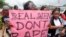 FILE - A woman carries a placard as she shouts a slogan during the "Walk Against Rape'" procession organized by Project Alert, a Lagos-based NGO focusing on women's issues, in Lagos, Nigeria, Oct. 5, 2011. 