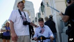 Jeff Morgan (L) and his father, World War II Marine veteran Eugene Morgan, both of Collierville, Tennessee, arrive to visit the World War II Memorial in Washington, Oct. 2, 2013.