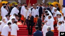 (กลาง) กษัตริย์นโรดม สีหมุนี ทักทายสมาชิกรัฐสภาที่ด้านหน้าของอาคารรัฐสภา เมื่อ 21 สิงหาคม 2023 (ที่มา:เอพี)