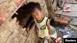 A boy plays in front of his house in Andong village, on the outskirts of Phnom Penh.