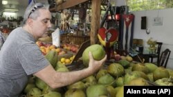 A shopper buying a coconut at a local fruit store in the Little Havana area of Miami, FL. 