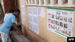 Les électeurs examinent une liste électorale devant un bureau de vote dans le quartier de Be à Lomé le 20 décembre 2018 lors de la procédure de vote pour les élections législatives.