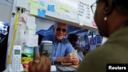 Democratic U.S. presidential candidate and former Vice President Joe Biden picks up an order at Scott's Bar-B-Que in Hemingway, South Carolina, Feb. 27, 2020. 