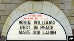 A man takes a photo of a the marquee of the Laugh Factory with a message in memory of actor Robin Williams displayed, in the Hollywood district of Los Angeles Monday, Aug. 11, 2014. 