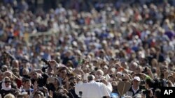 សម្តេច​ប៉ាប​ Francis (កណ្តាល) ដោះដូរ​មួក​របស់​ព្រះអង្គ​ជាមួយ​នឹង​មួក​ដែល​អ្នក​គោរព​សាសនា​បាន​ថ្វាយ​ព្រះអង្គ​ នៅ​ខណៈ​ដែល​ព្រះ​អង្គ​មកដល់​ទីធ្លារ​ St. Peter's Square ដើម្បី​ជួប​ជាមួយ​សាធារណៈជន​​ ប្រចាំ​សប្តាហ៍ ក្នុង​ទីក្រុង​វ៉ាទីកង់ កាលពីថ្ងៃទី​២២ ខែ​មេសា ឆ្នាំ២០១៥។ 