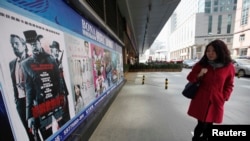 Seorang warga mengamati poster film "Django Unchained" di luar sebuah gedung bioskop di Beijing, 11 April 2013 (Foto: dok). Film garapan Quentin Tarantino ini ditarik dari peredaran pada hari pemutaran perdananya di China, Kamis (11/4) .