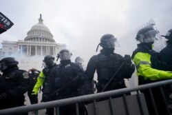 Trump supporters try to break through a police barrier, Jan. 6, 2021, at the Capitol in Washington.