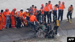 Seorang perempuan berusia 65 tahun (tengah), diselamatkan oleh para penyelam dari kapal Dongfangzhixing (Eastern Star) yang tenggelam di sungai Yangtze di Jianli, propinsi Hubei, China tengah (2/6). 