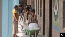 Displaced Yemenis receive food supplies provided by the World Food Programme, at a school in Sanaa, Yemen, Sunday, Aug. 25, 2019. 