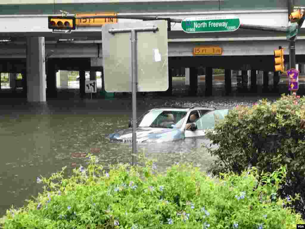 Floodwaters threaten to swallow a vehicle stranded on Interstate 45-North Freeway in Houston, Texas, Aug. 27, 2017. (C. Mendoza/VOA). 
