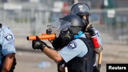 Policajac tokom nemira u Mineapolisu, zbog smrti Afroamerikanca koji je život izgubio tokom privođenja u tom gradu u srijedu, 27. maja 2020. (REUTERS/Eric Miller)