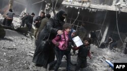 Wata mata tare da yara na gudun neman tsira biyo bayan harin dakarun gwamnatin Syria a yankin Ghouta.