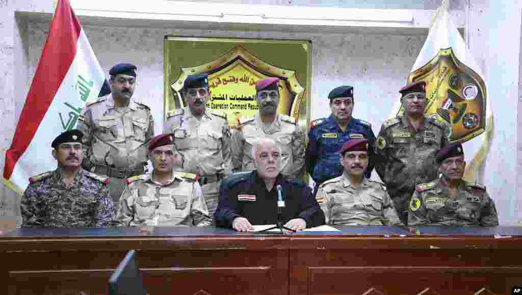 This photo released on his official Facebook page shows Iraqi Prime Minister Haider al-Abadi, center, surrounded by top military and police officers as he announces the start of the operation to liberate the northern city of Mosul from Islamic State milit