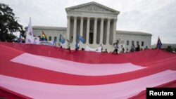 FILE - Supporters of gay marriage rally in front of the Supreme Court in Washington, June 26, 2015. A Massachusetts judge has ruled that an all-girls Catholic school violated state anti-discrimination law by rescinding a job offer to a gay man in a same-sex marriage.