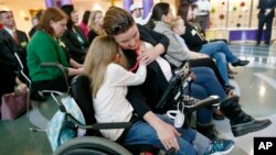 ARSIP – Abigail Gabriel, 8 tahun, memeluk ibunya, Erin, dari kursi rodanya saat Pjs Menteri Departemen Layanan Kemanusiaan, Teresa Miller, berbicara tentang Program Asuransi Kesehatan Anak (CHIP), dalam sebuah konferensi pers, 7 Desember 2017, di Pittsburgh (foto: AP Photo/Keith 