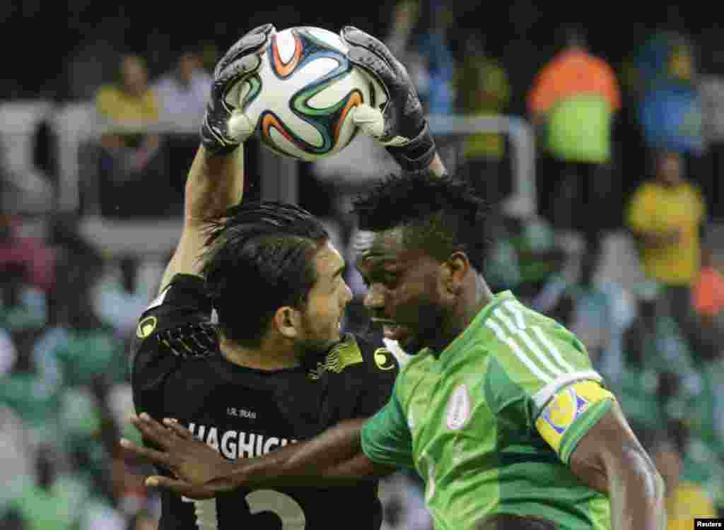 Iran&#39;s goalkeeper Alireza Haghighi (L) makes a save on Nigeria&#39;s Joseph Yobo during their 2014 World Cup Group F soccer match at the Baixada arena in Curitiba, June 16, 2014.