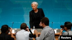 Photographers follow International Monetary Fund Managing Director Christine Lagarde as she arrives to discuss the IMF's annual review of the U.S. economy, in Washington, June 16, 2014. 