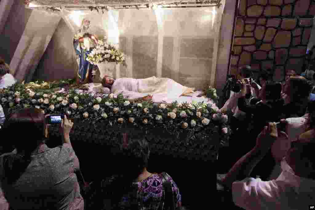 People take photos of a Jesus Christ statue at the end of a Holy Week mass at the Church of Divine Mercy in Panama City, Panama, March 28, 2013.