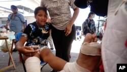 mhamiaji akipewa huduma ya kwanza baada ya kuumia mguu