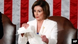 Nekadašnja predsedavajuća Predstavničkog doma Nensi Pelosi, koja je nosila belo odelo, cepa govor Donalda Trampa posle njegovog izlaganja o stanju nacije, 4. februar 2020. (AP Photo/Alex Brandon)