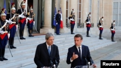 FILE - French President Emmanuel Macron meets Italian Prime Minister Paolo Gentiloni at the Elysee Palace in Paris, France, May 21, 2017. 