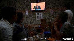 Des clients regardent à la télévision le leader de gauche Andres Manuel Lopez Obrador, du Mouvement National de la Régénération (MORENA), lors de la transmission du premier débat présidentiel dans un restaurant de Mexico, le 22 avril 2018..