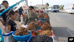 អ្នក​ដល់​ដូរ​នៅ​តាម​ផ្លូវ​ក្នុង​រាជធានី​ភ្នំពេញ​កាល​ពី​ថ្ងៃ​ទូ​១៦ ខែ​វិច្ឆិកា​ឆ្នាំ​២០០៧។ (រូប​ឯកសារ)