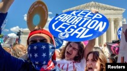 Seorang pedemo pendukung hak-hak aborsi mengacungkan poster bertuliskan "legalkan aborsi" di luar gedung Mahkamah Agung Amerika di Washington D.C. 24 Juni 2024. (Foto: Alex Brandon/AP Photo)