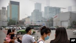 11일 중국 베이징 시민들이 마스크를 한 채 신호등을 기다리고 있다. 