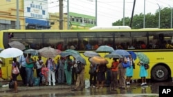 23일 자메이카 킹스턴에서 우산을 쓰고 버스를 기다리는 주민들.