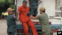 លោក យ៉ែម ជ្រិន (កណ្តាល) គ្រូពេទ្យ​គ្មាន​អជ្ញាបណ្ឌ​ ត្រូវបាន​មន្ត្រី​ពន្ធនាគារ​នាំ​ចុះ​ពី​រថយន្ត​ នៅ​ពេល​ដែល​លោក​បាន​មក​ដល់​តុលាការ​ខេត្ត​បាត់ដំបង​កាល​ពី​ថ្ងៃព្រហស្បតិ៍ ទី៣ ខែ​ធ្នូ ឆ្នាំ២០១៥។ (AP Photo/ម៉ៃ វីរៈ)