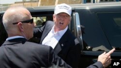 Presidential candidate Donald Trump talks to protesters as he leaves the World Trade Bridge border crossing in Laredo, Texas, July 23, 2015.