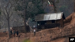 រូបឯកសារ៖ ក្នុងរូបដែលថត​នៅថ្ងៃទី៣០ ខែមីនា ឆ្នាំ២០២១នេះ បង្ហាញពី​ទាហាន​មីយ៉ាន់ម៉ា ឈរ​នៅ​ជំរំ​កងទ័ព​តូច​មួយ​តាម​បណ្តោយ​ច្រាំងទន្លេក្បែរ​ព្រំដែន​មីយ៉ាន់ម៉ា​និង​ថៃ។ ក្រុមឧទ្ទាម​ជនជាតិ​ភាគតិច​ Karen ថា ពួកគេ​បានកាន់កាប់​មូលដ្ឋានកងទ័ព​មីយ៉ាន់ម៉ា​កាលពី​ថ្ងៃអង្គារទី ២៧ ខែមេសាឆ្នាំ ២០២១។