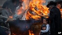 Ultra-Orthodox Jewish men and children burn leavened items in final preparation for the Passover holiday in the ultra-Orthodox Jewish town of Bnei Brak, near Tel Aviv, Israel, March 26, 2021.