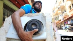 Qassem Istanbouli holds a film negative, in Tripoli, Lebanon, July 5, 2017. Istanbouli is restoring old cinemas into cultural centers.
