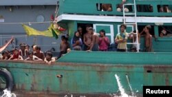 FILE - Some migrants despair after the Thai navy tows their boat away from Thailand, in waters near Koh Lipe island, May 16, 2015.