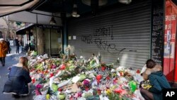 哀悼者把鲜花和蜡烛放在出事的巴黎餐厅前面（2015年11月15日）
