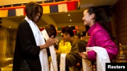 U.S. First Lady Michelle Obama, her daughters Sasha, Malia, and mother Marian Robinson are greeted with a Khata scarf by Tibetan students as they arrive to a Tibetan restaurant for lunch in Chengdu in southwest China's Sichuan province, March 26, 2014. 