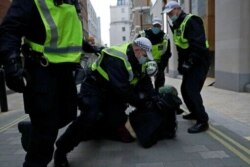 Police restrain a demonstrator during clashes following a 'Kill the Bill' protest in London, April 3, 2021. The demonstration is against the contentious Police, Crime, Sentencing and Courts Bill.
