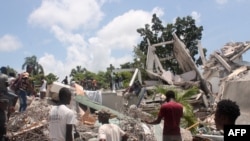 FILE - People search through the rubble of what used to be the Manguier Hotel after the earthquake hit on Aug. 14, 2021 in Les Cayes, southwest Haiti.