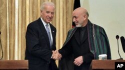 Afghan President Hamid Karzai, right, shakes hands with US Vice President Joe Biden during a press conference in Kabul, 11 Jan 2011