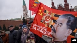 Communist party supporters carry flags with portraits of Soviet dictator Josef Stalin during a demonstration marking the 100th anniversary of the 1917 Bolshevik revolution in Red Square, in Moscow, Russia, Nov. 5, 2017. 
