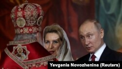 RUSSIA -- Russian President Vladimir Putin reacts next to Svetlana Medvedeva, wife of the prime minister, as Russian Orthodox Church Patriarch Kirill conducts the Orthodox Easter service at the Cathedral of Christ the Saviour in Moscow, April 28, 2019