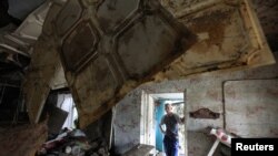 Warga mengamati bangunan yang hancur dilanda banjir bandang di kota kecil Krymsk wilayah Krasnodarsky, Rusia, (8/7). 