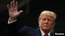 Republican presidential candidate and former U.S. President Donald Trump waves as he visits a caucus site at Horizon Event Center in Clive, Iowa, Jan. 15, 2024.
