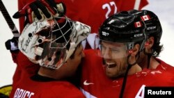 Canada's Shea Weber (R) celebrates with goalie Carey Price after Canada won their men's ice hockey semi-final game against Team USA at the 2014 Sochi Winter Olympic Games, February 21, 2014. 
