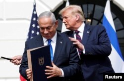 Perdana Menteri Israel Benjamin Netanyahu berdiri bersama Presiden AS Donald Trump setelah menandatangani Perjanjian Abraham yang menormalisasi hubungan Israel dengan beberapa negara Timur Tengah, di Washington, 15 September 2020. (Foto: Tom Brenner/Reuters)